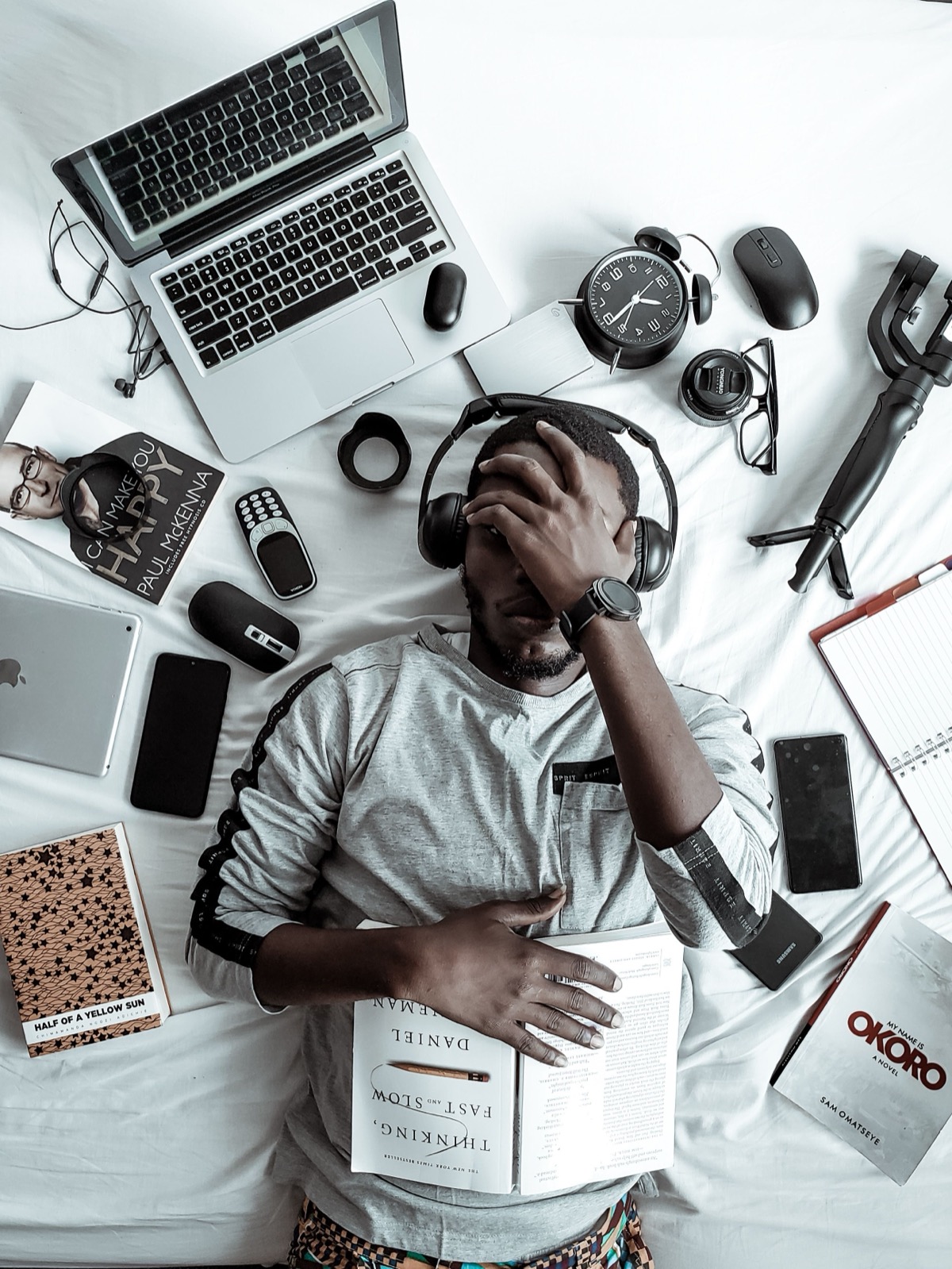 Business owner working at a desk surrounded by books and technology, facing the reality of compliance risks